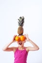 Cheerful child playing with oranges, pineapple and banana. The c