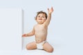 Portrait of little sweet toddler boy, baby in diaper sitting isolated over white studio background. Cheerful baby Royalty Free Stock Photo