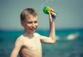 Cheerful child in swimware playing in sea with toy