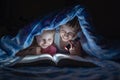 Cheerful children, brother and sister lie under the covers and read a book