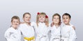Cheerful children in karategi on a gray background Royalty Free Stock Photo