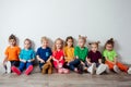 Cheerful children sitting on a floor near the wall Royalty Free Stock Photo