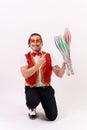 Cheerful circus performer skillfully juggling a number of clubs isolated on white background Royalty Free Stock Photo