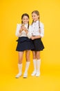 Cheerful classmates with smartphone. little girls in school uniform. back to school. educational blog. new technology in Royalty Free Stock Photo