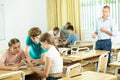 Classmates and teacher working in groups to complete task during class