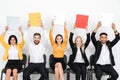 Cheerful colleagues sitting in office holding folders. Royalty Free Stock Photo