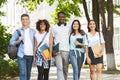 Cheerful college students walking out of campus together, posing outdoors Royalty Free Stock Photo