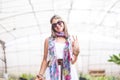 Cheerful coloured hippy style free and smiling young blonde alernative woman with coloured clothes pose in front of the camera and