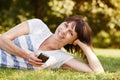 Cheerful comfortable woman lying in grass with smart phone Royalty Free Stock Photo