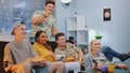 Cheerful company watching TV, eating snacks and enjoying time together Royalty Free Stock Photo