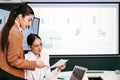 A cheerful and confident Asian businesswoman sitting and discussing documents of her office colleagues during the meeting. Royalty Free Stock Photo