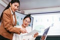 A cheerful and confident Asian businesswoman sitting and discussing documents of her office colleagues during the meeting. Royalty Free Stock Photo