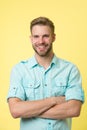 Cheerful consultant. Man smiling face posing confidently with folded arms yellow background. Man shop consultant looks Royalty Free Stock Photo