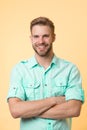 Cheerful consultant. Man smiling face posing confidently with folded arms yellow background. Man shop consultant looks Royalty Free Stock Photo