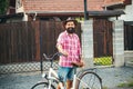 Cheerful country man. Handsome young man smiling while riding bike in rural village.