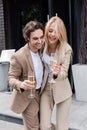 cheerful couple in beige stylish suits