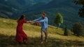 Cheerful couple dance mountains. Happy lovers have fun hold hands at nature view Royalty Free Stock Photo