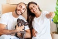 Cheerful couple with dog sitting on floor in new home Royalty Free Stock Photo