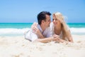 Cheerful couple embracing and lying on the beach on a sunny day Royalty Free Stock Photo