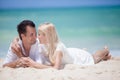 Cheerful couple embracing and lying on the beach on a sunny day Royalty Free Stock Photo