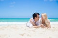 Cheerful couple embracing and lying on the beach on a sunny day Royalty Free Stock Photo