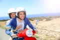 Cheerful couple enjoying scooter ride in the islands