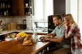 Cheerful couple enjoys a light-hearted moment in their sunny kitchen, working on laptop surrounded by a healthy breakfast Royalty Free Stock Photo