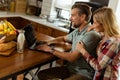 Cheerful couple enjoys a light-hearted moment in their sunny kitchen, working on laptop surrounded by a healthy breakfast Royalty Free Stock Photo