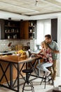 Cheerful couple enjoys a light-hearted moment in their sunny kitchen, working on laptop surrounded by a healthy breakfast Royalty Free Stock Photo