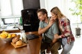 Cheerful couple enjoys a light-hearted moment in their sunny kitchen, working on laptop surrounded by a healthy breakfast Royalty Free Stock Photo