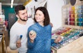 cheerful couple examining various paints in paint store Royalty Free Stock Photo