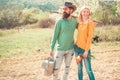 Cheerful couple of farmers standing in vegetable garden. Young Couple gardening in the garden. Portrait of pair of farms