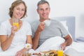 Cheerful couple having breakfast in bed together Royalty Free Stock Photo