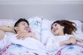 Cheerful couple laughing together on bed