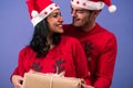 Cheerful couple looking at each other, smiling holding a nice Christmas present Royalty Free Stock Photo