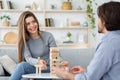 Cheerful couple in love playing Jenga at home