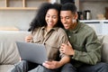 Cheerful couple in love spending leisure time online with laptop at home. Young woman and man looking at the laptop Royalty Free Stock Photo