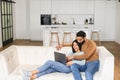 Cheerful couple in love spending leisure time online with a laptop at home. Young woman and man looking at the laptop Royalty Free Stock Photo