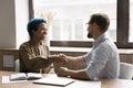 Cheerful couple of office colleagues shaking hands, laughing Royalty Free Stock Photo