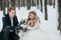 Cheerful couple are playing with siberian husky in snowy forest. Winter wedding Artwork Royalty Free Stock Photo