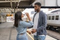 Cheerful couple at a railway station waiting for the train on the platform, arriving at the destination Royalty Free Stock Photo