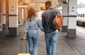 Cheerful couple at a railway station waiting for the train on the platform, arriving at the destination Royalty Free Stock Photo