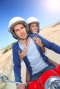 Cheerful couple on a red scooter enjoying riding Royalty Free Stock Photo