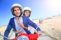 Cheerful couple riding moto in desertic island