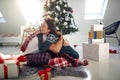 A cheerful couple sitting on the floor in a hug surrounded by Xmas presents. Christmas, relationship, love, together Royalty Free Stock Photo