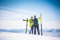 Cheerful couple of skiers in front of snowy mountains