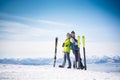 Cheerful couple of skiers in front of snowy mountains