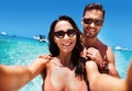 Cheerful couple taking a selfie in a tropical clear water