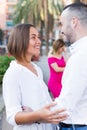 Cheerful couple are talking and woman is envying them