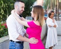 Cheerful couple are talking and woman is envying them